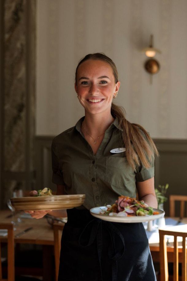 Kellnerin mit Tellern im Restaurant Toftastrand.
